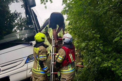 Die anrückenden Rettungskräfte setzten eine Leiter ein, um den Fahrer sicher und unverletzt aus dem Bus zu holen. Foto: -/Feuerw
