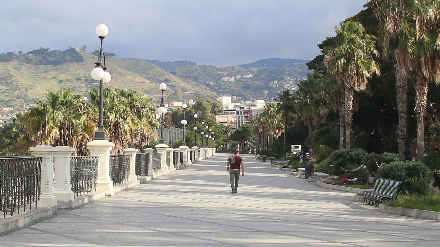Ein Mann geht in Reggio Calabria an einer leeren Promenade spazieren. Die italienische Region Kalabrien ist die Heimat der auch