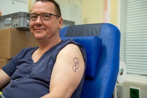 Konstantin Bolwin hat sich das Symbol der Organspende auf den Oberarm tätowieren lassen. Foto: Max Lametz/dpa