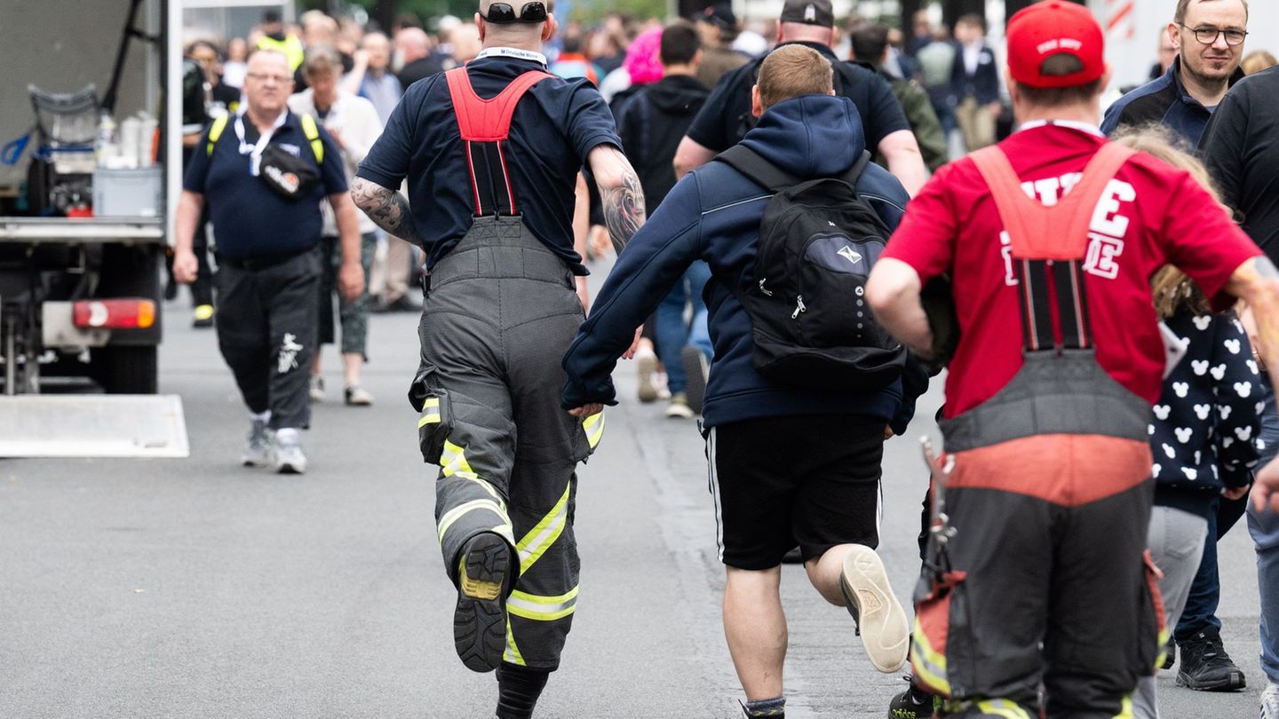 Besucher rennen zu Messebeginn auf der Messe Interschutz, um in Halle 15 einen von 1.000 kostenlosen Rucksäcken am Stand von Hai