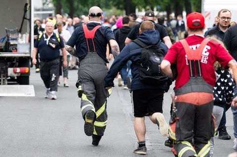 Besucher rennen zu Messebeginn auf der Messe Interschutz, um in Halle 15 einen von 1.000 kostenlosen Rucksäcken am Stand von Hai