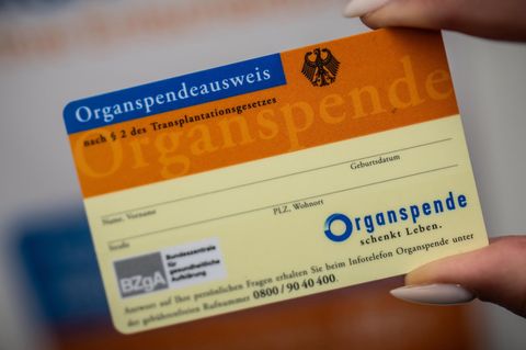 Hand hält Organspender-Ausweis