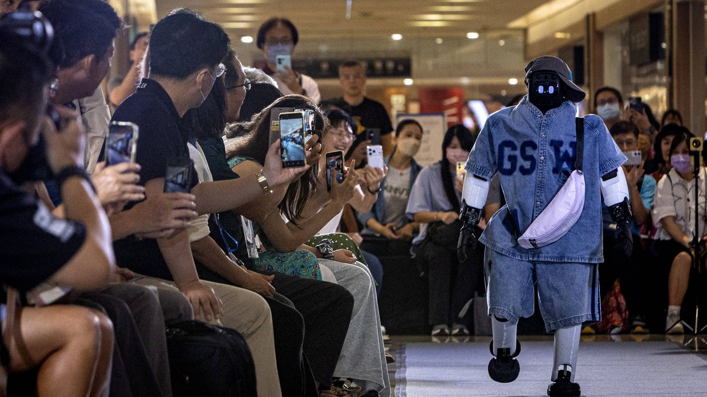 Kaohsiung, Taiwan. Ein humanoider Roboter läuft bei der EDA Fashion Show 2026 unter dem Motto „Fashion Genesis“ über den Laufsteg. In Taiwan findet erstmals eine Roboter-Modenschau statt. Die Zuschauer scheinen begeistert.