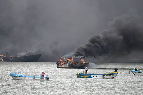 Im Hafen von Manta stehen mehrere Fischerboote in Flammen. Foto: Ariel Ochoa/AP/dpa