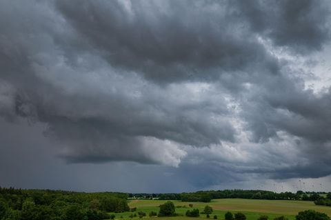 Symbolfoto für Artikel über Kaltfront: Dunkle Gewitterwolken ziehen über einen Windpark
