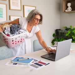 Frau wäscht Wäsche im Homeoffice und begeht Arbeitszeitbetrug