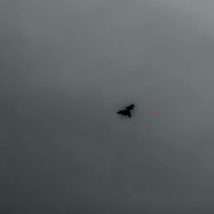 Die schwarze Silhouette eines Kampfflugzeugs unbekannter Bauart