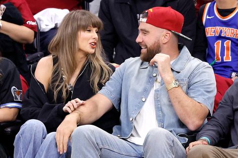 Taylor Swift und Travis Kelce sitzen am Spielfeldrand eines Basketballspiels und unterhalten sich