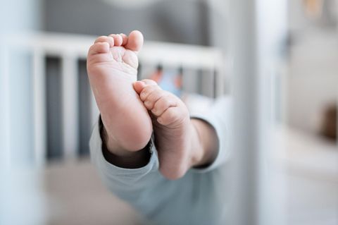 Ein Baby streckt seine Füße in die Kamera
