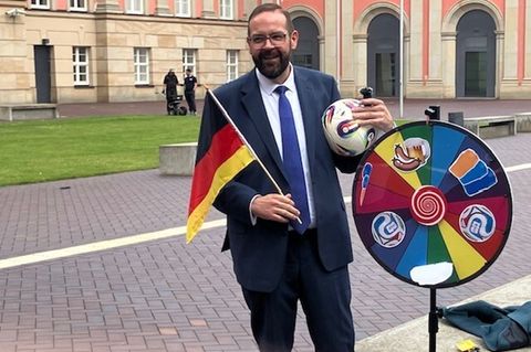 Aktion zur Fußball-WM: Brandenburgs Sportminister Gordon Hoffmann (CDU) dreht vor dem Landtagsgebäude an einer Art Glücksrad für