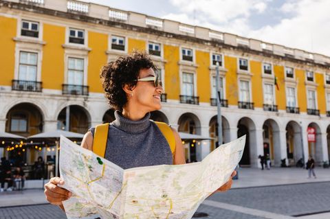 Eine Frau auf Reisen mit Stadtplan in einer Stadt