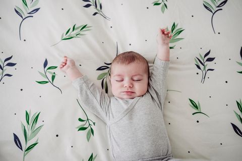 Baby streckt sich im Bett