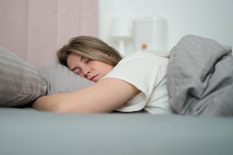 Eine Frau schläft im Bett.