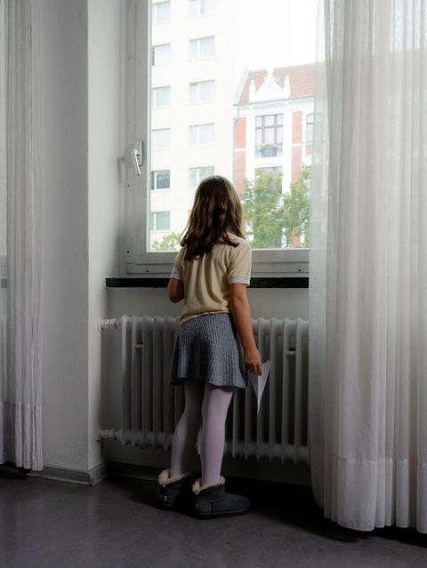 Jüdische Jugend: Ein kleines Mädchen steht vor einem Fenster und schaut raus