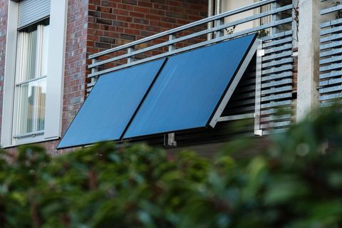 Solarpanels eines Balkonkraftwerks am Balkon eines Mehrfamilienhauses