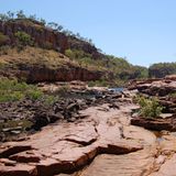 Annäherung an den Nitmiluk-Nationalpark mit Bus, Boot und zu Fuß: Über die Jahrmillionen hat sich der George River in das Armhem-Plateau gefräst. Bis zu 70 Meter ragen die Sandsteinfelsen in die Höhe. Für die Aborigines hat das Schluchtsystem auch eine spirituelle Bedeutung. Wörtlich übersetzt bedeutet Nitmiluk: Ort der Zikaden-Traumpfade.