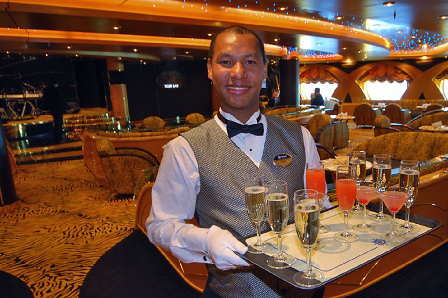 Willkommen an Bord in einer der 17 Bars: Zur Begrüßung werden Cocktails in der Tigerbar mit Fell-Ambiente gereicht, ehe das Schiff gegen 19 Uhr für die Taufzeremonie mit Sophia Loren Richtung Landungsbrücken ablegt und Eros Ramazzotti ein Konzert gibt