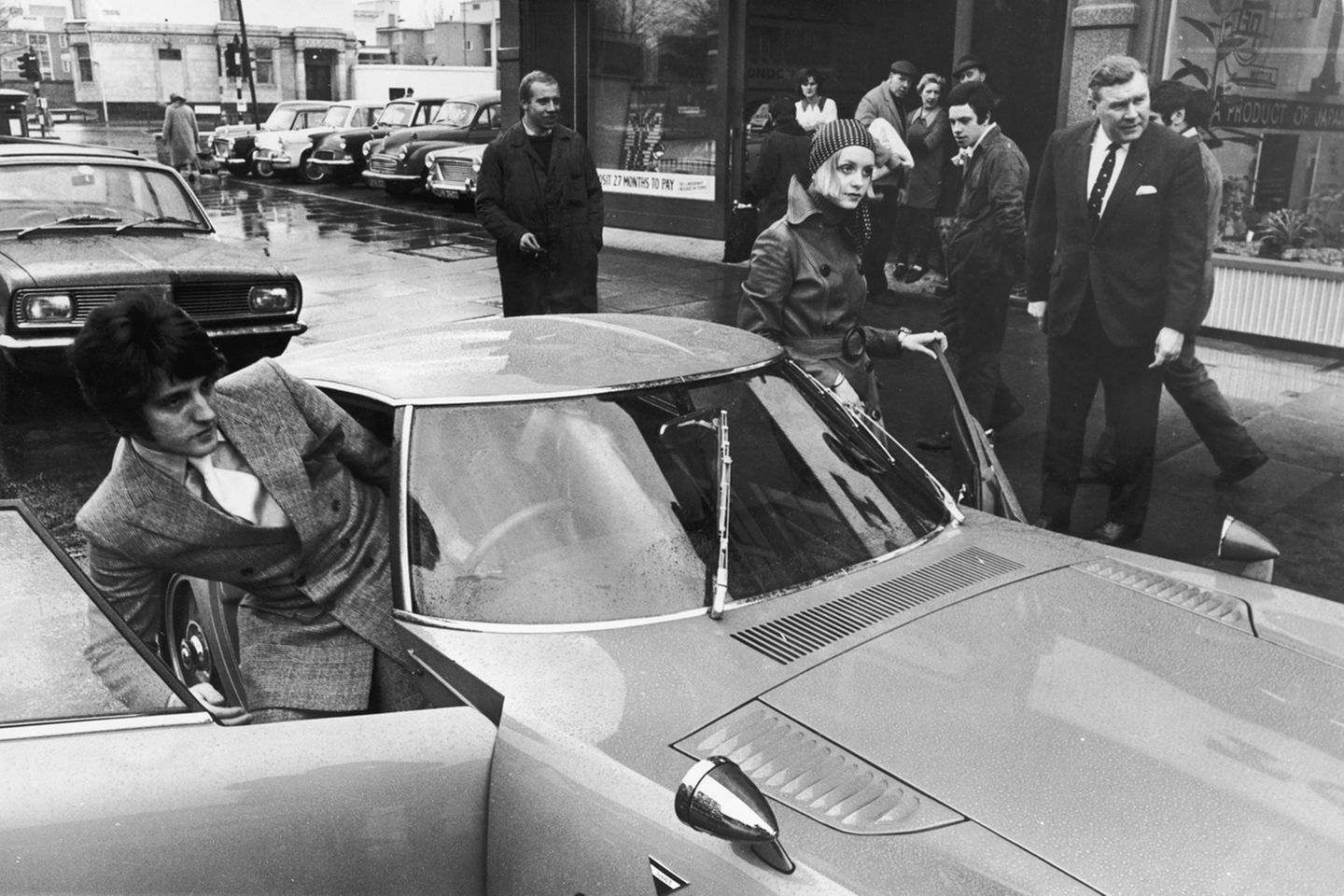 Als erstes Supermodel war Twiggy eine begehrte Werbeikone. 1968 bekam sie - noch 18-jährig - einen Toyota 200 GT Sportwagen geschenkt. Weil sie zu der Zeit noch gar keinen Führerschein besaß, musste ihr Manager Justin De Villeneuve (l.), mit dem sie zu dieser Zeit auch liiert war, hinterm Steuer Platz nehmen.