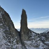 Auf die Spitze getrieben: An der freistehenden 50 Meter hohen Felsnadel Ago del Torrone im Schweizer Bergell haben sich 28 Bergführer an Seilen fixiert. Sie mussten so lange ausharren, bis das aus dem Hubschrauber geschossene Stachelbild im Kasten war.