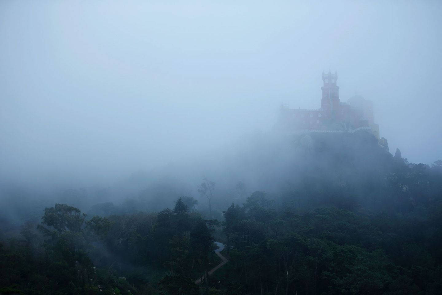 Der blaue Dunst verstärkt die romantische Aura des auf einem Berg gelegenen Palácio Nacional da Pena