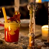 Currywurst Cocktail  Ein flüssiger Tribut an die Currywurst: Wodka mit fruchtigem Paprika-Tomaten-Püree. Darauf eine Krone aus Curryschaum und dazu würzige Serrano-Schinken-Chips. So schön kann Fast Food sein.  Zutaten:  20ml Wodka  45ml Tomaten-Paprika-Püree*  Curryschaum**  Cannelloni  Trinkgefäß: Weckglas  Garnitur: rote Beeren  1 Serrano-Chip***  Zubereitung:  Den Wodka mit dem Tomaten-Paprika-Püree im Glas auf Eis rühren. Den Curryschaum on top geben und mit dem Serrano-Chip und roten Beeren garnieren. Die nicht gekochte Canneloni als Trinkhalm in das Glas geben.  *150 ml gelbes Paprikapüree, 150 ml rotes Paprikapüree, 500 ml Tomatensaft, 100 ml Zitronensaft, 12 Dashes Tabasco und 10 Dashes Worcestersauce gleichmäßig vermengen und mit Salz und Pfeffer abschmecken.  **350ml Wasser mit 3 EL Currypulver in eine Flasche geben und schütteln. Die Flasche unter gelegentlichem Schütteln über 24 Stunden ziehen lassen. Das Currywasser passieren und mit 50ml Sahne, 50ml Läuterzucker und 50ml Eiweiß in einen Sahnesiphon geben. Mit 3 Sahnekapseln unter Druck setzen.  ***Serrano-Schinken in dünnen Scheiben schneiden und bei 50°C für 15 Stunden in ein Dörrgerät geben. Für eine längere Lagerung luftdicht verschließen.