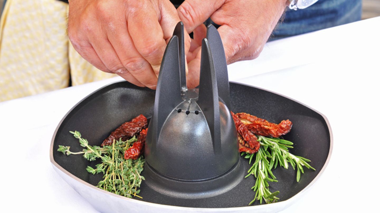 Spezielle Hähnchensitze sind nicht nur standfester als Bierdosen. Sie bieten noch Platz für wirklich würzige Beigaben, wie hier im Bild frischer Thymian, Rosmarin und getrocknete Tomaten.