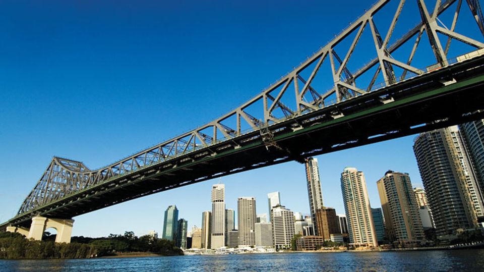 Was haben die Harbour Bridge in Sydney und Auckland sowie die Story Bridge im australischen Brisbane gemeinsam? Sie lassen sich nicht nur mit dem Auto oder zu Fuß auf der Fahrbahn überqueren, sondern auch über ihre weit geschwungenen Bögen. Dieser nicht alltägliche Ausflug gilt als Adrenalinkick einer Stadtführung der besonderen Art.   Im Vergleich zu den anderen beiden Brücken gilt die Klettertour auf die Spitze des Hauptpfeilers in Brisbane, der Hauptstadt des Bundesstaates Queensland, als besonders abenteuerlich. "Die Story Brücke verängstigt die Leute viel mehr als die Harbour Bridge in Sydney", sagt Simon, einer der Guides. Statt einem Geländer gibt es nur Stahlseile zum Festhalten. 1138 luftige Gitterroststufen sind bei dem Bridge Climb zu bewältigen.