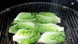 Die Temperatur über den Kohlen beträgt etwa 250 Grad, die flache Seite bekommt schnell ein leichtes Brandig, also geröstete Streifen vom Grillrost. Verbrennen sollte der Salat jedoch nicht, haben Sie also stets ein Auge drauf!