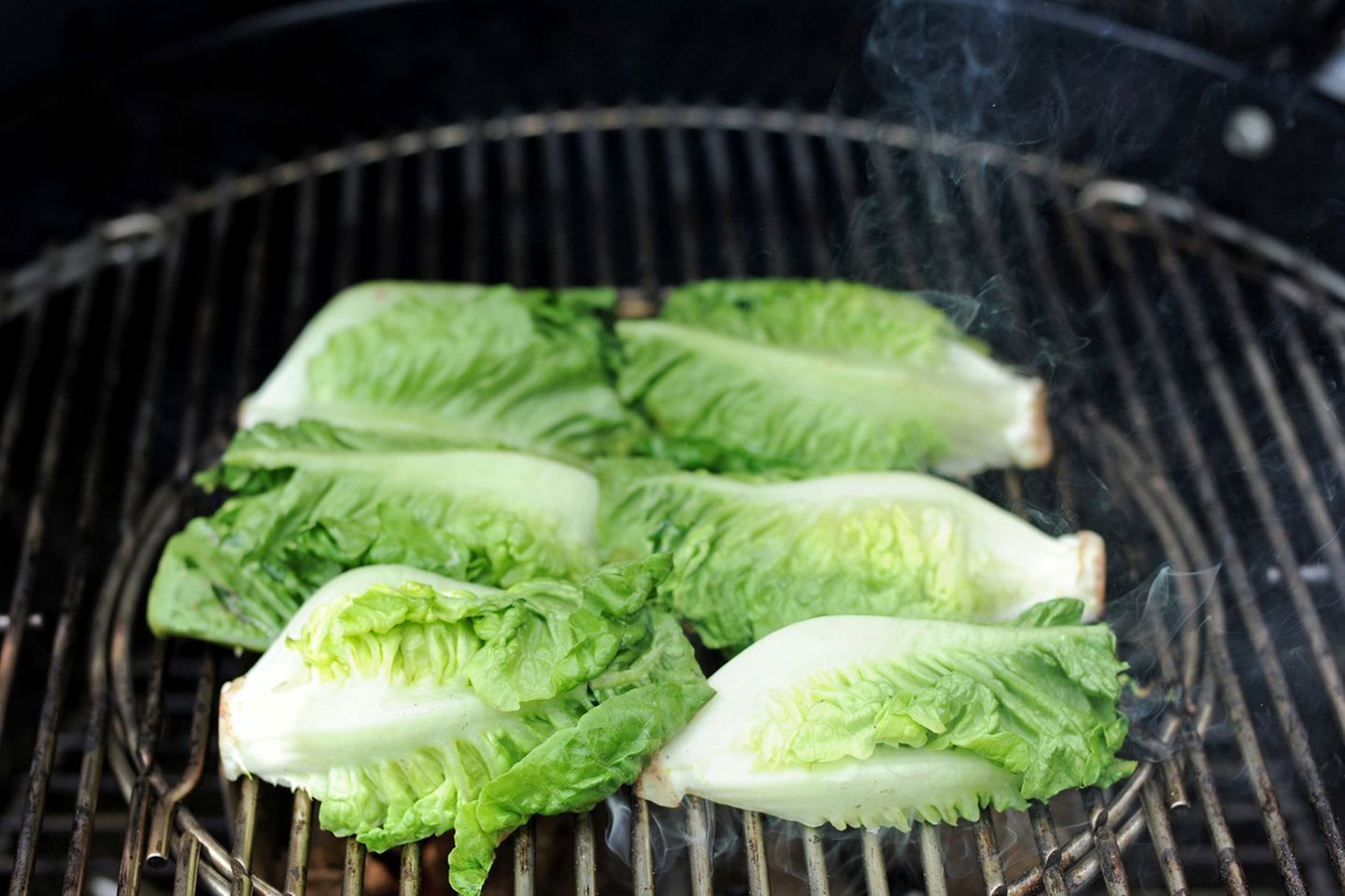 Die Temperatur über den Kohlen beträgt etwa 250 Grad, die flache Seite bekommt schnell ein leichtes Brandig, also geröstete Streifen vom Grillrost. Verbrennen sollte der Salat jedoch nicht, haben Sie also stets ein Auge drauf!