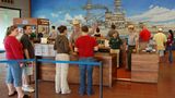 Pearl Harbor  Sie warten auf Einlass zum Freilichtmuseum, wo einst für die USA der Zweite Weltkrieg begann: Hawaiis Hauptattraktion ist die Gedenkstätte für die Opfer des Überraschungsangriffs. "This is not a drill - dieses ist keine Übung", lautete ein verzweifelter Funkspruch am Morgen des 7. Dezember 1941. Die militärische Niederlage bleibt beim Rundgang durch den öffentlichen Teil der Marinebasis stets gegenwärtig. Das aus Spenden finanzierte Visitor Center beherbergt einen Kinosaal und einen Souvenir Shop mit Dutzenden von DVD-Dokumentationenen und dem Reprint einer Tageszeitung, deren Zeile lautet: "War declared. 3000 Casualties in Jap Attack on Hawaii".