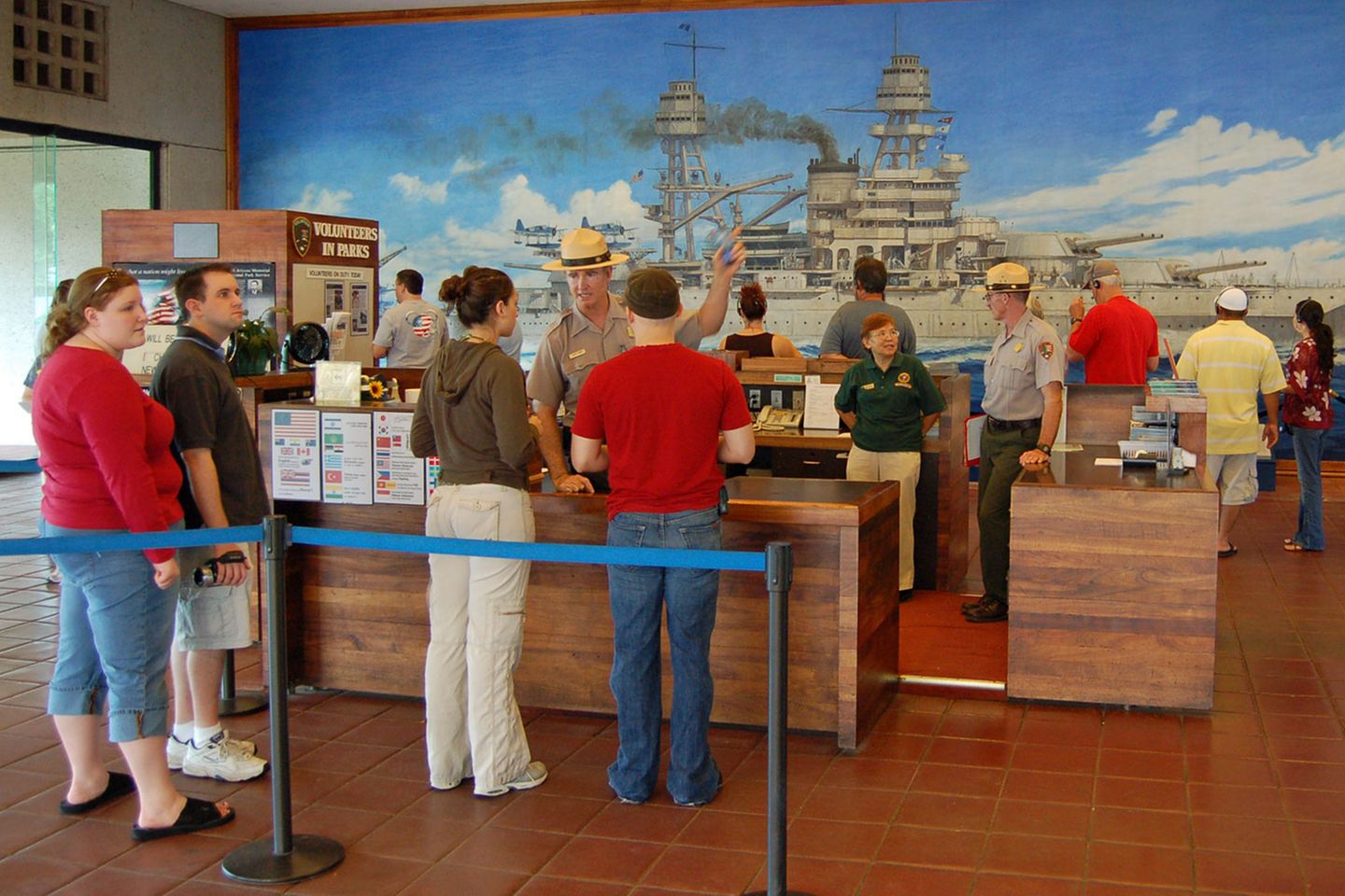 Pearl Harbor  Sie warten auf Einlass zum Freilichtmuseum, wo einst für die USA der Zweite Weltkrieg begann: Hawaiis Hauptattraktion ist die Gedenkstätte für die Opfer des Überraschungsangriffs. "This is not a drill - dieses ist keine Übung", lautete ein verzweifelter Funkspruch am Morgen des 7. Dezember 1941. Die militärische Niederlage bleibt beim Rundgang durch den öffentlichen Teil der Marinebasis stets gegenwärtig. Das aus Spenden finanzierte Visitor Center beherbergt einen Kinosaal und einen Souvenir Shop mit Dutzenden von DVD-Dokumentationenen und dem Reprint einer Tageszeitung, deren Zeile lautet: "War declared. 3000 Casualties in Jap Attack on Hawaii".