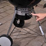 Mit dem oberen Hebel wird die Luftzufuhr geregelt. Bei reduzierter Frischluftzufuhr brennt die Holzkohle länger und bei geringer Temperatur. Auf diese Weise lassen sich zum Beispiel Spareribs drei, vier Stunden bei etwa 100 Grad garen. Das Fleisch fällt anschließend wie von allein vom Knochen, abnagen unnötig. Der Grillmeister hat daher beim indirekten Grillen das Thermometer im Auge und hebt nicht ständig den Deckel an. Wer mit dem indirekten Grillen noch unerfahren ist, sollte den Hebel immer auf maximale Luftzufuhr stellen.