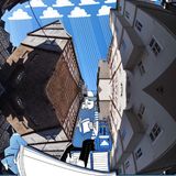 Bei dem auf den Bildern immer wieder auftauchenden bärtigen Mann, der hier über den Dächern von Marburg entspannt seine Beine ins Boot baumeln lässt, könnte es sich um ein Selbstbildnis handeln. Zumindest hat Lamadieu einen Bart.   Die Facebook-Seite von Roots Art