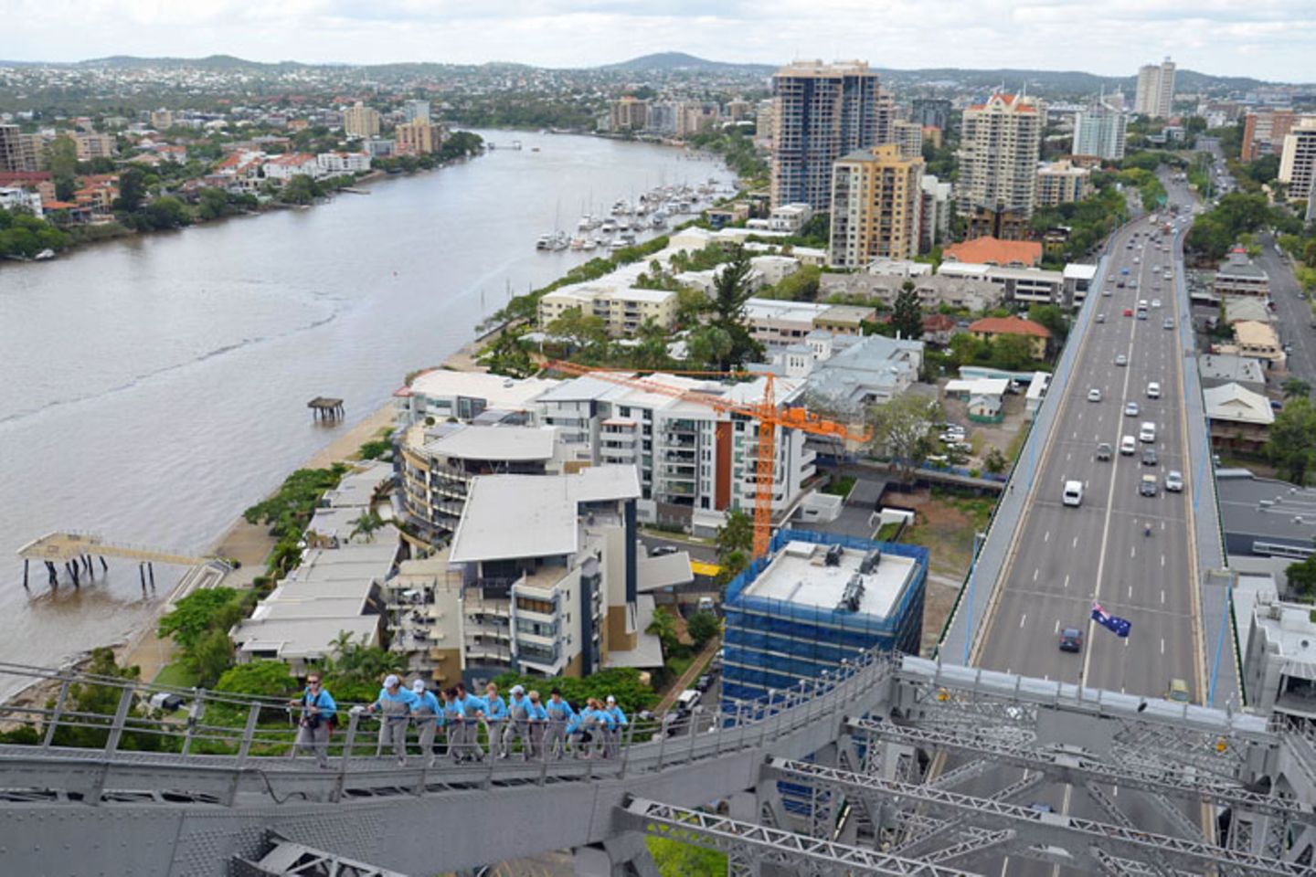 Brisbane Story Bridge Climb: Aufwärts im Gänsemarsch: Jeder der Bridge Climber steckt in einem speziellen blau-grauen Overall, um den Autofahrern keine Abzulenkung zu bieten. Das Tragen einer Armbanduhr, von Schmuck oder einer Kamera ist untersagt. Selbst Sonnenbrille, Kopfbedeckung und Taschentuch sind über Kordeln am Körper fixiert. Aufwärts im Gänsemarsch: Jeder der Bridge Climber steckt in einem speziellen blau-grauen Overall, um den Autofahrern keine Abzulenkung zu bieten. Das Tragen einer Armbanduhr, von Schmuck oder einer Kamera ist untersagt. Selbst Sonnenbrille, Kopfbedeckung und Taschentuch sind über Kordeln am Körper fixiert.