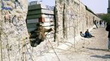 Die Mauer war schon gefallen, doch die DDR bestand noch: ein Grenzsoldat inmitten der Mauerreste