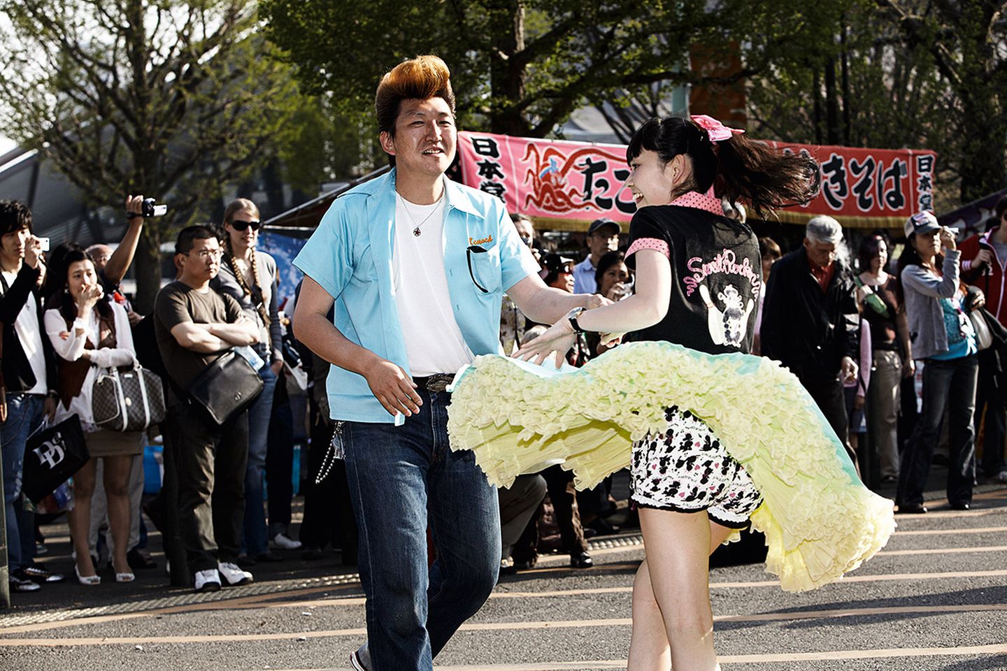 Im Yoyogi Park in Tokio entdeckte der Fotograf die lebendige Subkultur: Aus Boxen ertönte lauter Rock'n'Roll, und die Rockabillys und Rockabellas begannen zu tanzen. Ganz so, als befänden sie sich in einem Club, und nicht im öffentlichen Park.