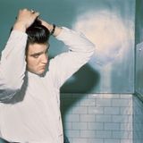 Im Juni 1956 war Elvis bereits ein Star und veröffentlichte seine ersten Songs beim großen RCA-Label. Auf der Toilette des Mosque Theater in Richmond, Virginia frisiert sich der 21-jährige Sänger vor einem Auftritt.  Das Foto entstammt dem Bildband "Alfred Wertheimer. Elvis and the Birth of Rock and Roll" (Taschen Verlag)