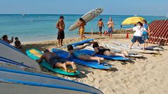 Trockenübungen an Land  In Waikiki packt man nicht nur die Badehose ein, sondern nimmt statt des Sonnenschirms ein Surfboard mit zum Strand. Schon ein kurzer Tageskurs reicht, um später auf Wellen zu reiten. Die Kurse beginnen zunächst mit Trockenübungen auf festem Untergrund. Oft geben knackige Beachboys jungen Japanerinnen Surfunterricht.
