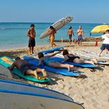 Trockenübungen an Land  In Waikiki packt man nicht nur die Badehose ein, sondern nimmt statt des Sonnenschirms ein Surfboard mit zum Strand. Schon ein kurzer Tageskurs reicht, um später auf Wellen zu reiten. Die Kurse beginnen zunächst mit Trockenübungen auf festem Untergrund. Oft geben knackige Beachboys jungen Japanerinnen Surfunterricht.