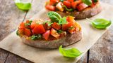Bruschetta  Bruschetta kommt vom italienischen Wort bruciare für verbrennen. Gemeint ist das römische Brot, das leicht angebrannt ist. Das ist sehr typisch für die römische Bruschetta. Das angeröstete Brot wird mit Knoblauch eingerieben und mit Tomaten und Olivenöl belegt. Hier im Bild sieht man eine Variation mit getrockneten Tomaten. Hier geht's zum Rezept.