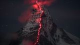 Auf dem nächtlichen Hörnligrat, der Route der Erstbegeher am Matterhorn, hat Bösch zusammen mit Zermattern Bergführern Alpinisten mit roten Stirnlampen positioniert, deren Schein die Wolkenfetzen am Gipfel zum Leuchten bringt.