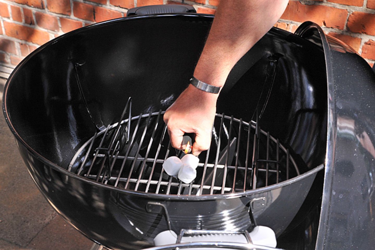 … das obere Grillrost abnehmen und auf das untere drei Grillanzünder, meist Parafinwürfel, entzünden …