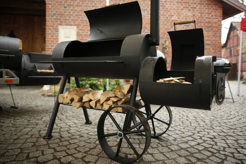 Immer mehr ambitionierte Griller in Deutschland wagen sich an die nächste Stufe der Fleischzubereitung im Freien: dem Garen bei niedrigen Temperaturen um die 90 bis 110 Grad. Das Gerät für diesen Job ist der Smoker. Er heißt so, weil er mit heißem Rauch das Fleisch langsam durchgart. Feuer und Grillgut sind strikt voneinander getrennt. An der Seite etwas unterhalb der Garkammer, ist die Hitzequelle angebracht, die Sidefirebox. Hier wird mit Holzscheiten ein Feuer entfacht. Hitze und Rauch ziehen in die Garkammer, über das Grillgut hinweg und dann über ein Ofenrohr nach oben wieder ab.