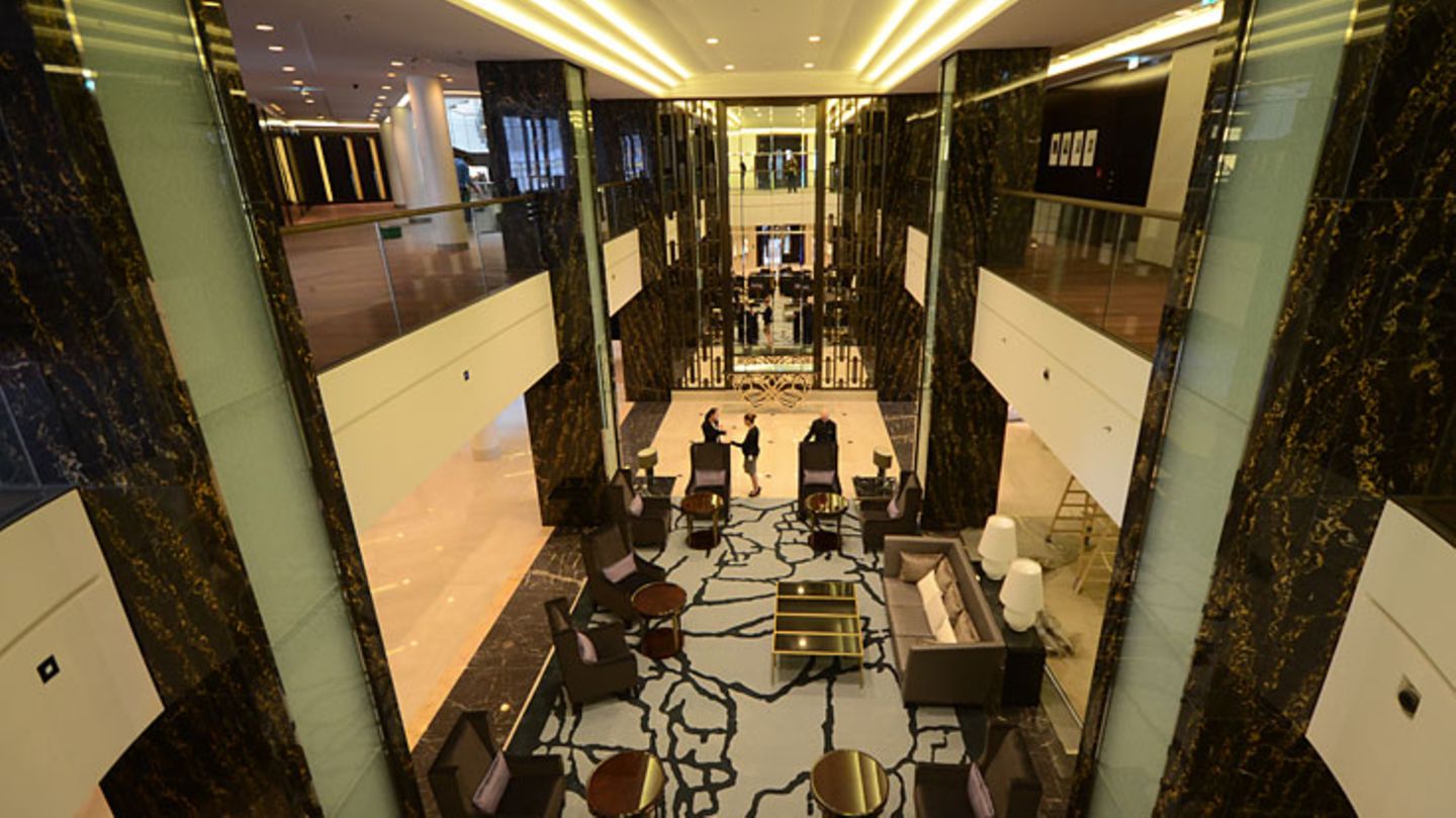 Über zwei Stockwerke erstreckt sich die Lobby, die an das Interieur eines Transatlantikdampfers aus den späten zwanziger Jahren erinnert. Der Empfangsbereich wirkt fast intim, man fühlt sich auch nicht verloren wie in anderen Großhotels. Im Gegensatz zu den klaustrophobisch-niedrigen Decken des Hotels Adlon, dem Hauptkonkurrenten, bietet das neue Waldorf Astoria viel Raum. Blickfang sind die Säulen aus schwarzem italienischem Marmor mit schimmernden Goldadern.