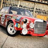 1971 betrat das AMG-Rennteam mit einem grellroten 300SEL erstmals die internationale Tourenwagenbühne und errang beim Einstandsrennen - den 24 Stunden von Spa Francochamps - promt den zweiten Gesamtrang. Der Motor mit seinen 6,8 Litern Hubraum aus acht Brennkammern war dabei ein Segen.   Dieser überraschende Erfolg bildete den Grundstein für das bis heute andauernde Rennengagement von AMG. Die Firma V-Classics aus Dresden steckte sich das ehrgeizige Ziel, den ersten aller AMG-Renner optisch originalgetreu nachzubauen. Man sichtete alte Fotografien, Pläne und Zeichnungen um dem Original optisch so nahe wie möglich zu kommen.  Dem Innenleben wurde allerdings ein Kraftwerk auf dem neuesten Stand der Technik spendiert, zu viel Originalität wäre hier zum Sicherheitsrisiko geworden: Der 6,3-Liter-V8-Motorblock aus dem Basisfahrzeug wurde auf die authentischen 6,8 Liter Hubraum aufgebohrt.