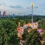 Die Beecker Kirmes ist eine der größten Ereignisse zwischen Niederrhein und Ruhrgebiet. Im Hintergrund sind die stillgelegten Hochöfen von Thyssen zu sehen.