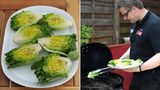 Und nun ab auf den Grill. Den Salat grillen wir mit direkter Hitze. Grillmeister Breinig hat die beiden Kohlekörbe in die Mitte des Grill gezogen und legt den halbierten Salat mit der flachen Seite nach unten direkt über die Kohlen.