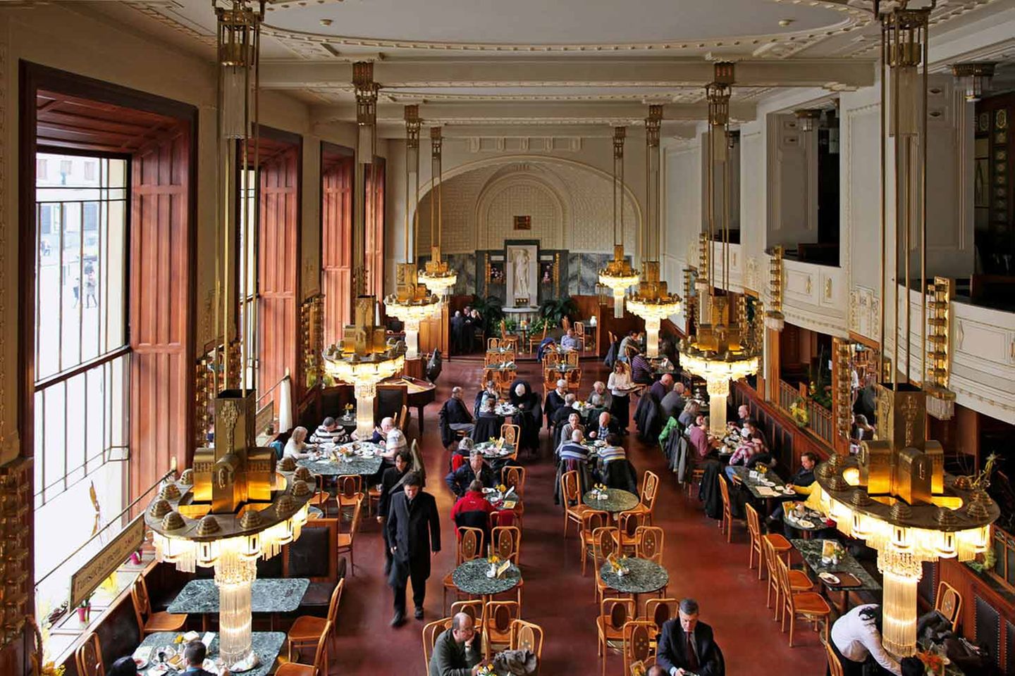 Kavárna Obecní Dum, Prag  Das Gemeindehaus, in welchem sich das Café befindet, steht ganz im Zeichen des klassischen Prager Jugendstils. Das Repräsentationsgebäude steht an historisch bedeutsamer Stelle, denn ab dem 14. Jahrhundert befand sich dort der Königshof. Im 20. Jahrhundert musste dieser jedoch dem Gemeindehaus weichen, das Raum für Kultur und Erholung zur Verfügung stellen sollte.  Am 28. Oktober 1918 wurde hier sogar die Unabhängigkeit der Tschechoslowakei proklamiert. Das Café erstrahlt in ornamentaler Jugendstilpracht, der zweigeschossige Saal mit Galerie besticht vor allem durch seine acht auffälligen Kronleuchter.