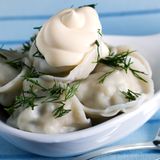 Pelmeni sind eine Art russische Tortellini. Russen essen sie am liebsten mit einer Schweinehackfüllung, Zwiebeln und Knoblauch. Es gibt sie als Suppeneinlage oder als Hauptgericht. Traditionell wird dazu Smetana (Schmand) gegessen. Und was in osteuropäischen Küchen nie fehlen darf: frischer Dill.