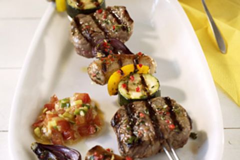 Steak und Würstchen am Schaschlikspieß aufgereiht, dazwischen frisches Gemüse